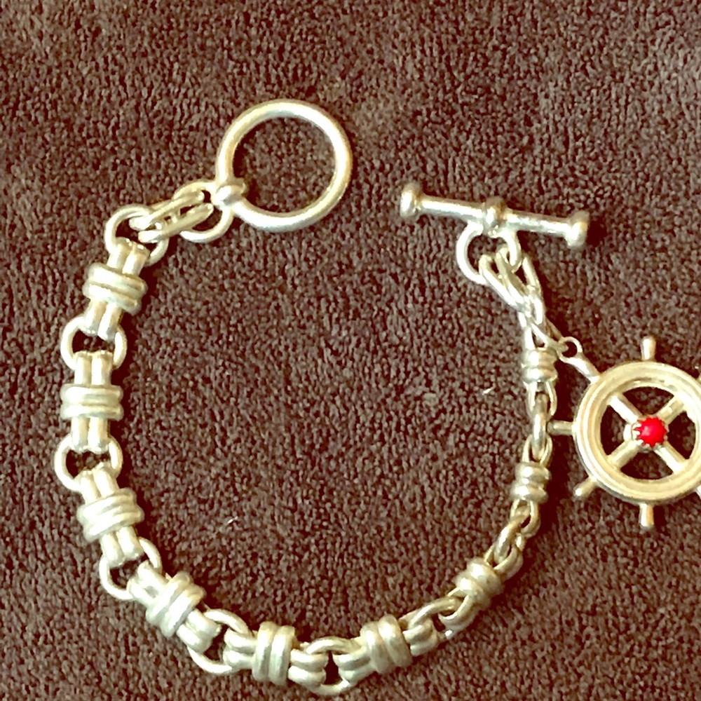 Silver bracelet with silver and coral charm.